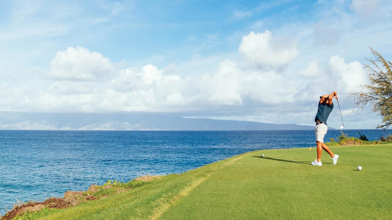 Golfer on green with ocean in background
