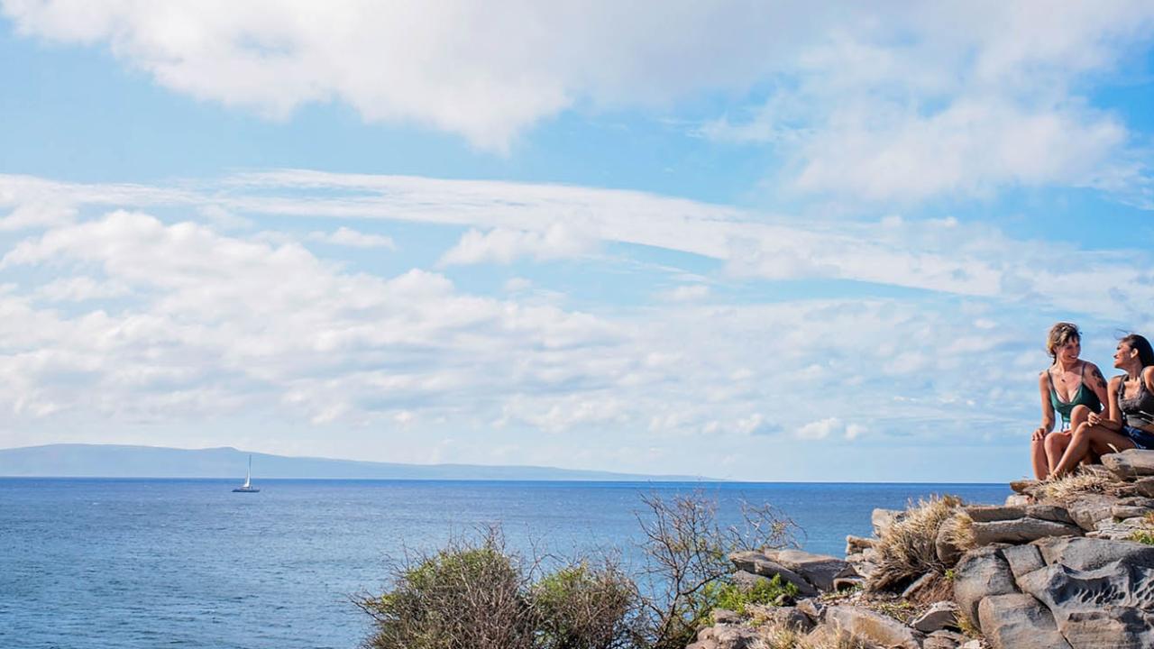 Ladies sitting on rock bed overlooking ocean on Maui