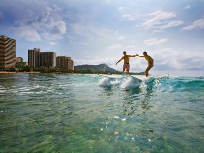 Couple surfing off Waikiki Beach