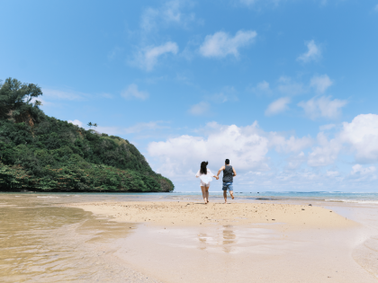 Couple running along Anini Beach