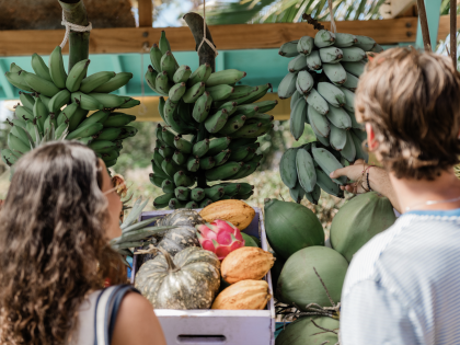 Man and women pick local fruit at a farmer's market