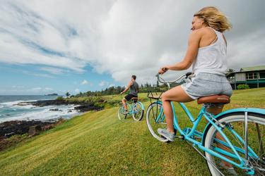 Couple riding bikes by the beach