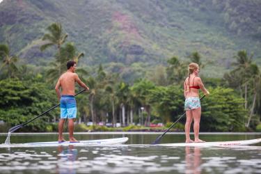 two people paddling boarding on a river